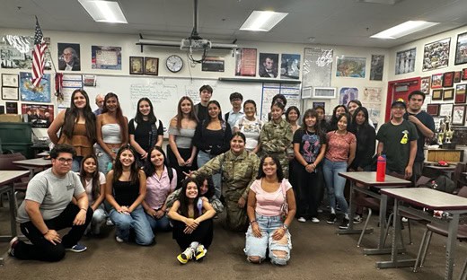 A group of smiling teenagers in a classroom